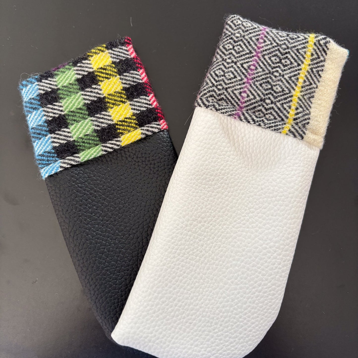 Two fabric-covered phone cases with geometric patterns on a black background