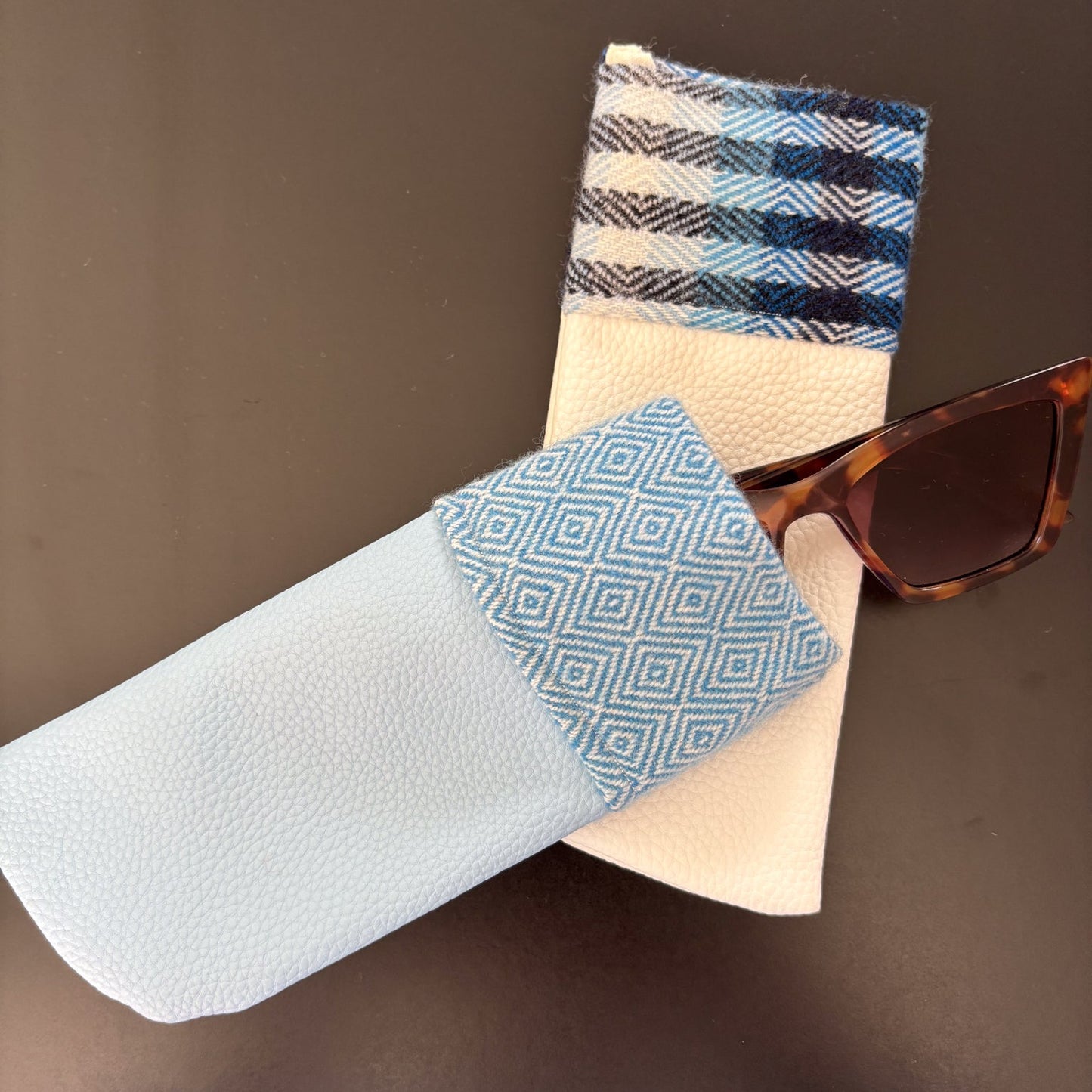 Sunglasses with a patterned case on a brown background