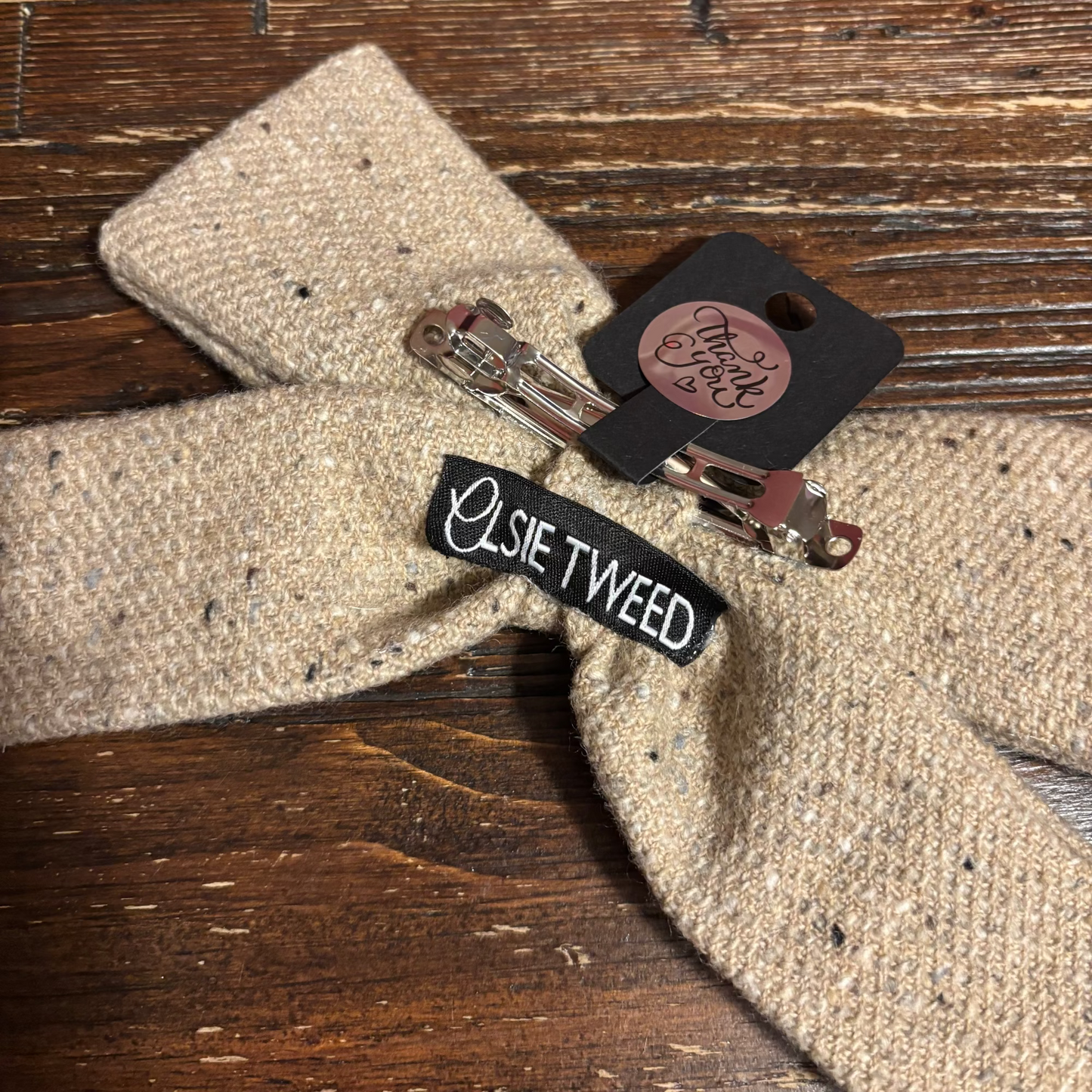 Hair accessories including a hair clip and a black label on a textured surface