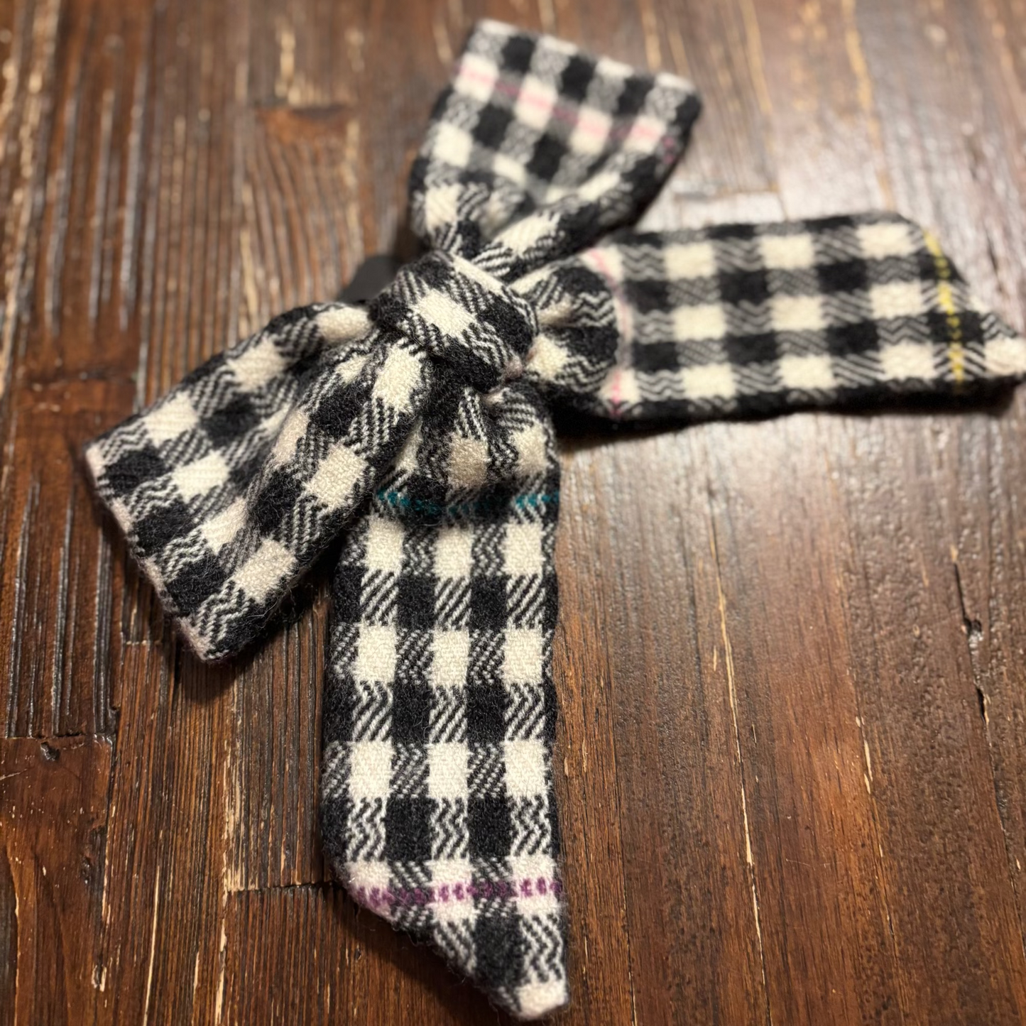 Plaid tweed woven hair bow on a wooden surface