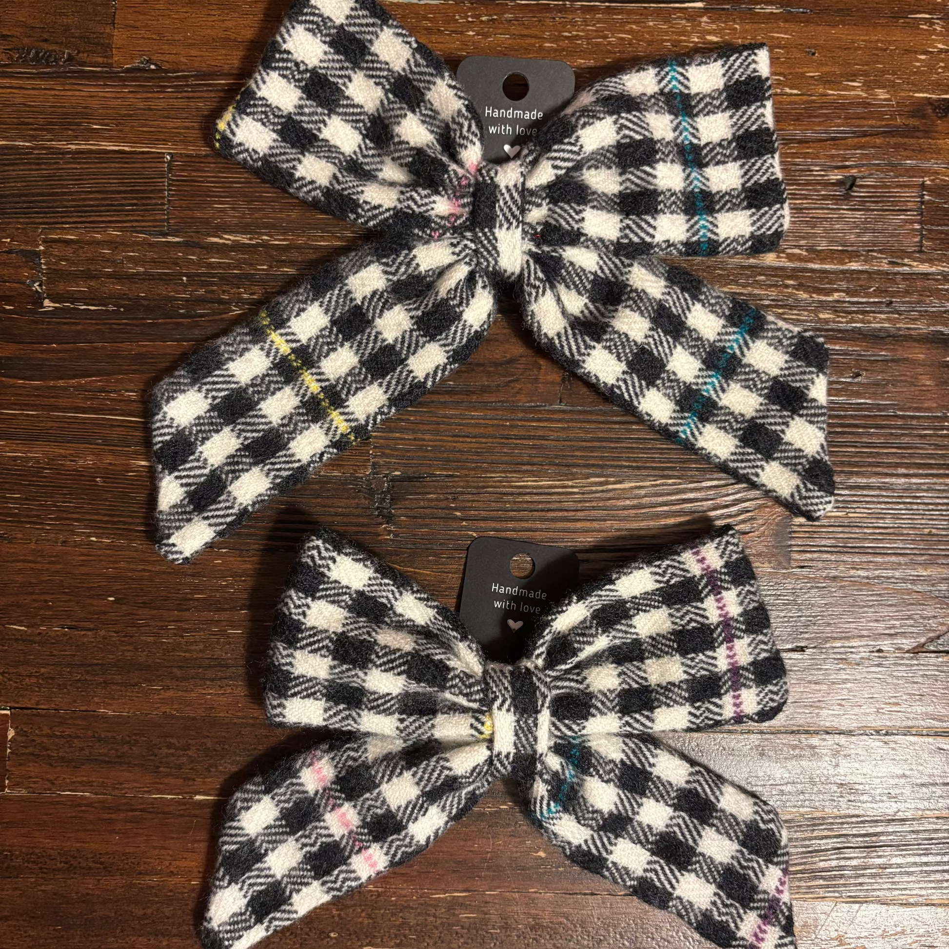 Two checkered bows on a wooden surface