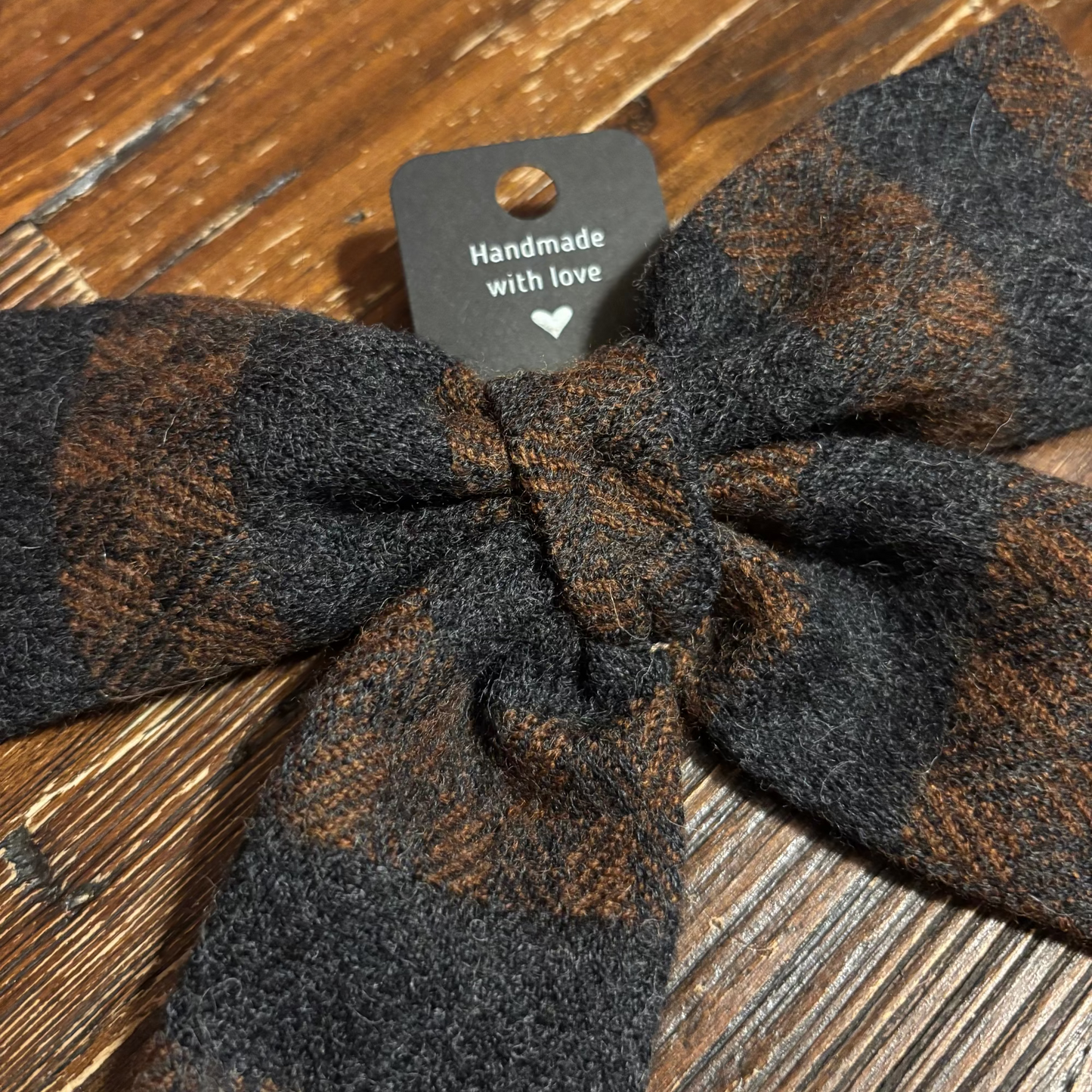 Plaid headband with 'Handmade with love' tag on a wooden surface