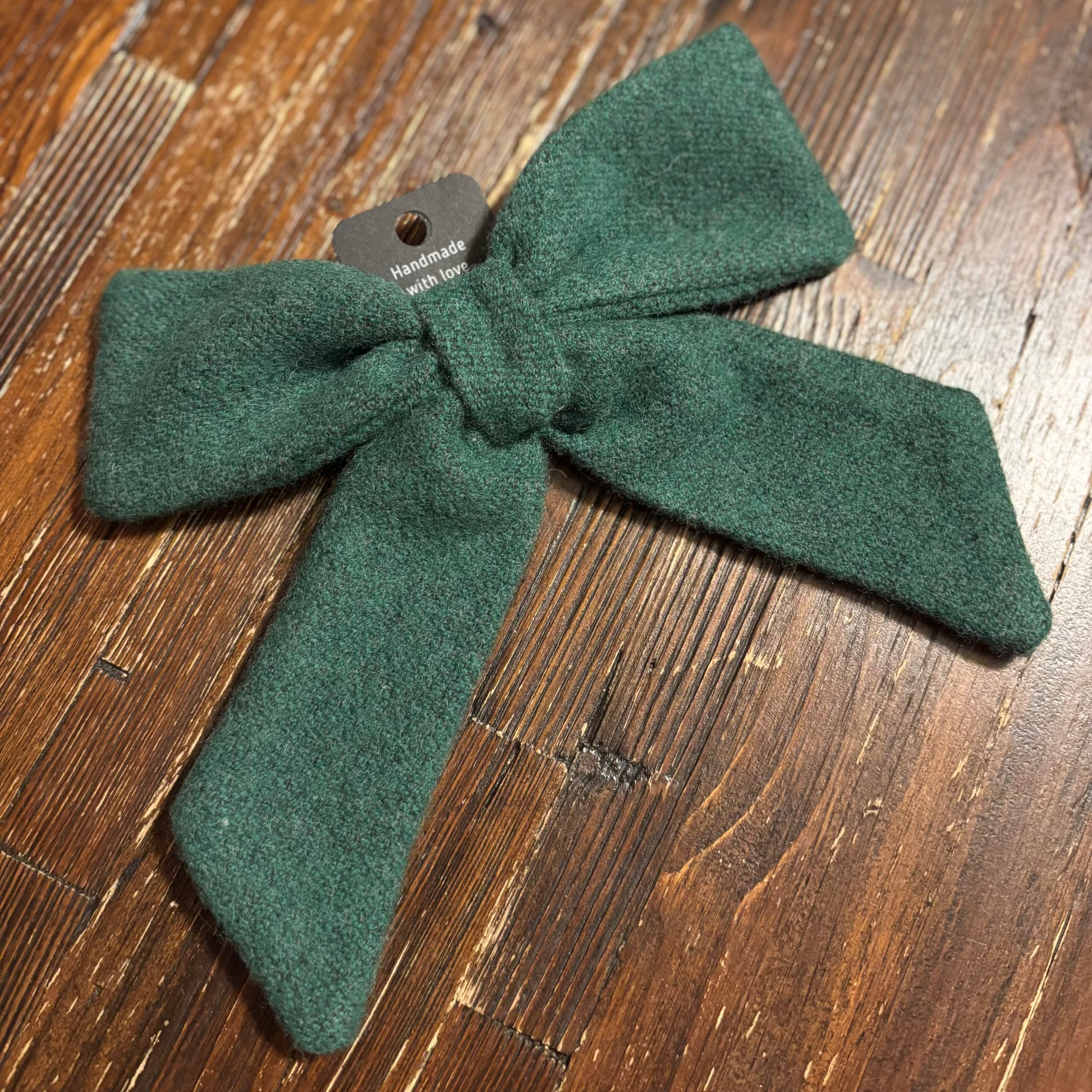 Green bow hair accessory on a wooden surface