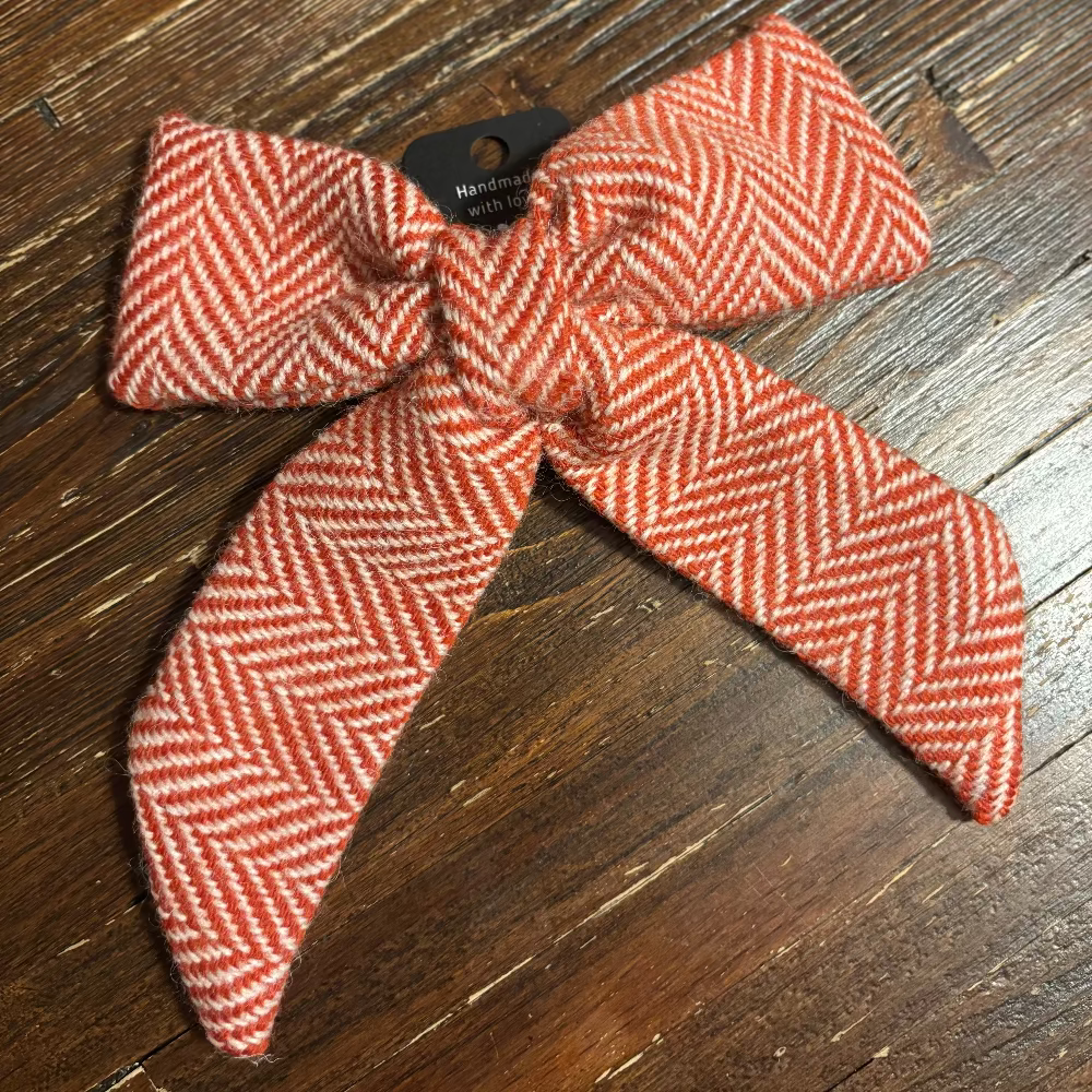orange and white herringbone patterned bow on a wooden surface