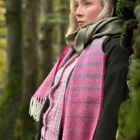 Woman wearing a pink and green plaid scarf in a forest setting