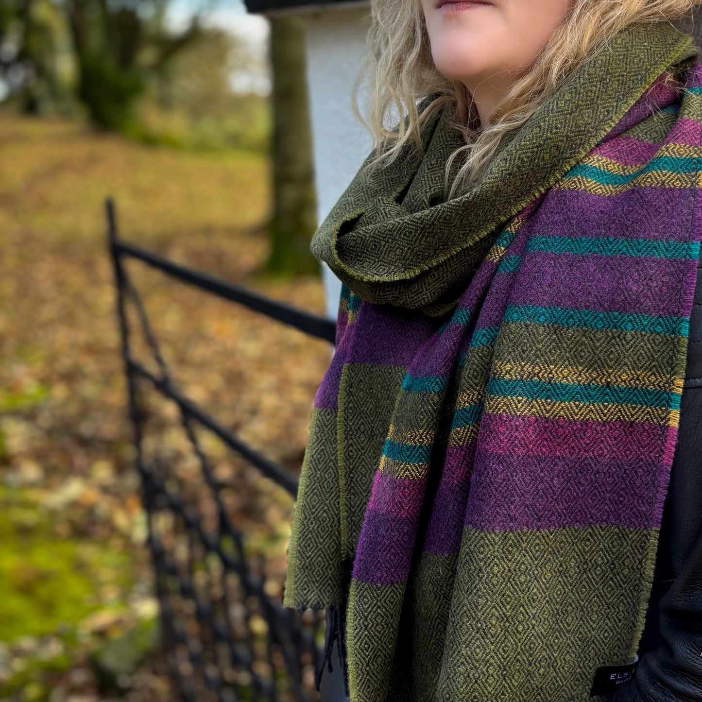 Person wearing a green and purple striped scarf outdoors