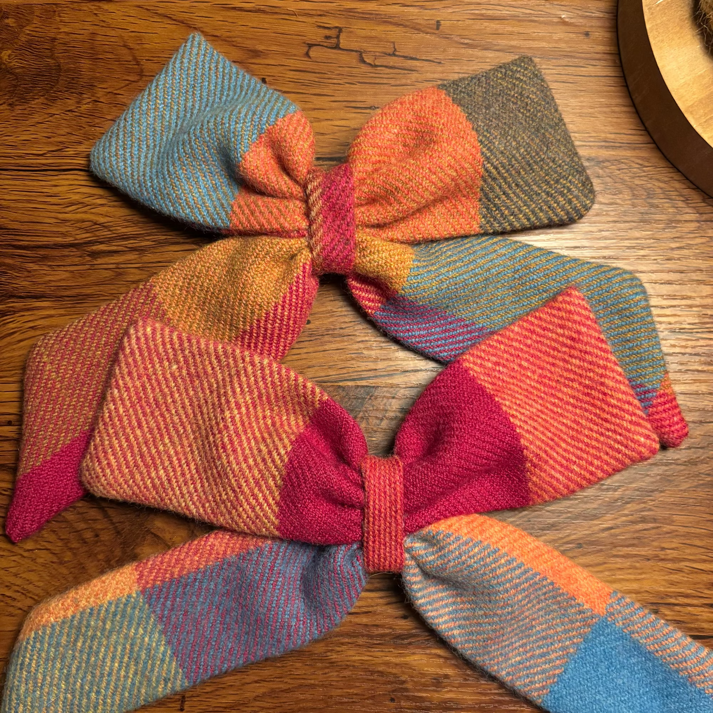 Person with plaid hair bows in their hair against a blurred indoor background