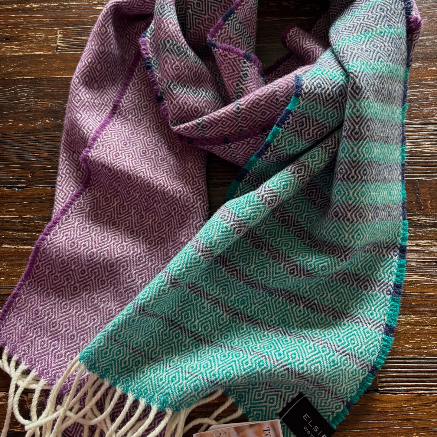 Woven scarf with geometric pattern on a wooden surface