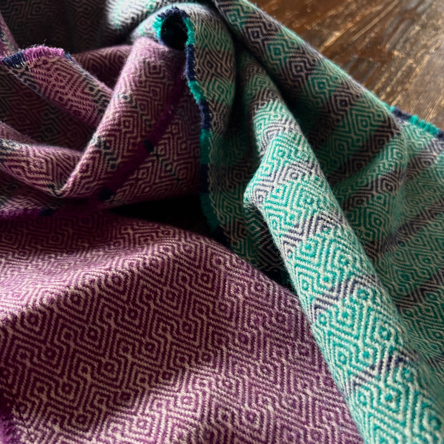 Close-up of purple and green patterned fabric on a wooden surface